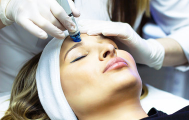 Facial cleansing procedure, deep vacuum hydro-peeling. Young woman enjoying a radiant face in a...