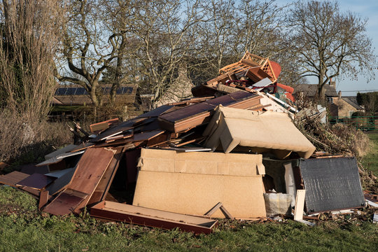 Large-scale, illegal fly tipping seen in a rural location. Showing household furniture and other home items illegally dumped overnight.