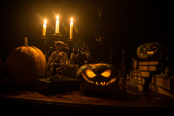 Halloween still-life background with different elements on dark toned foggy background. Selective...