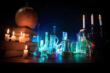 Halloween still-life background with different elements on dark toned foggy background. Selective focus