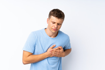 Young handsome man over isolated white background having a pain in the heart