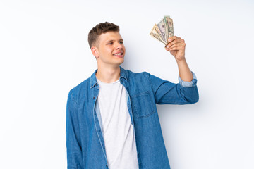 Young handsome man over isolated white background taking a lot of money