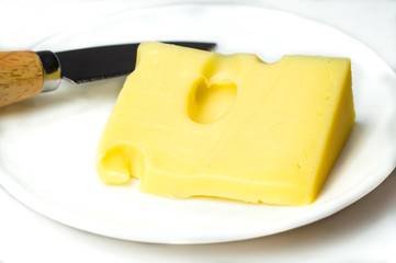Cheese with a cheese knife on a white plate