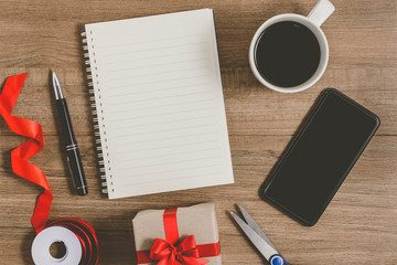 New Year's Resolutions List written on Notebook with gift box and smart phone, pen, coffee