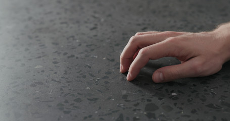 young man hand finger tap on terrazzo countertop