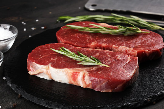 Steak raw. Barbecue Rib Eye Steak or rump steak on dark rustic table