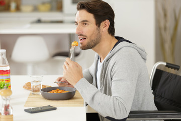 man eating a meal in his wheelchair