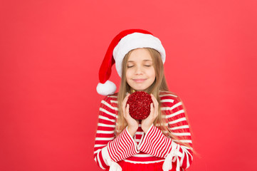 Take your gift and make a wish. Little girl hold red gift ball. Small child with santa look. Christmas Gift. Xmas Present. New year gift