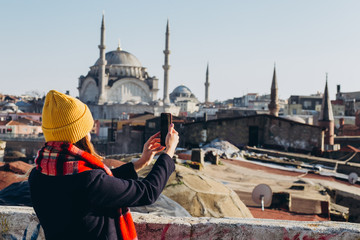 Young european woman takes a selfie portrait in Istanbul, Turkey. girl walks through winter...