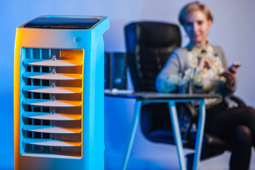 Portable air conditioner. Air conditioning installed in the office. Girl sitting behind the air...