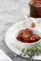 sun-dried tomatoes in a plate on a light concrete background