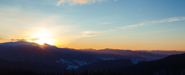 Sunrise in the mountains. Beautiful view of the mountains from a high point. Dawn in mountain...