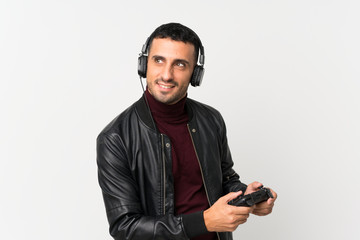 Young man over isolated white background playing at videogames