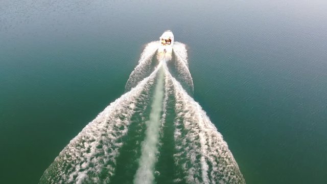 A speedoat driving on the water with peaople haveing fun