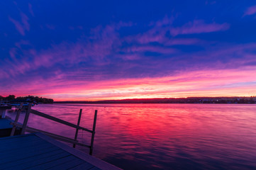 Naklejka na ściany i meble Vivid ultra violet sunset over calm water at Silver Lake, NY State