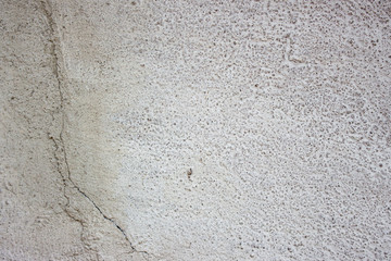 White concrete wall with cracks.