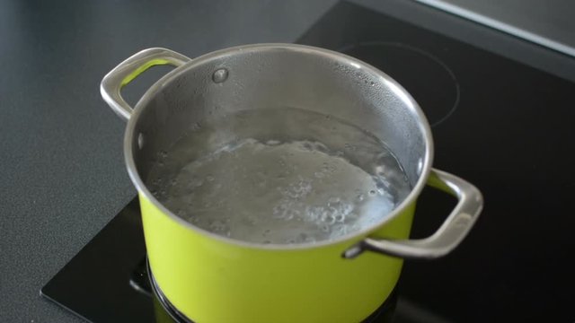 Saucepan full of boiling water on induction stove.