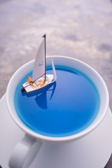 Miniature people, Rowing boat in the ocean in cup.  Image use for life style concept.