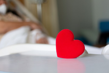 red heart on blurred patient background