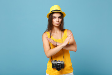 Traveler tourist woman in yellow summer casual clothes hat with photo camera isolated on blue background. Female sad passenger traveling abroad to travel on weekends getaway Air flight journey concept