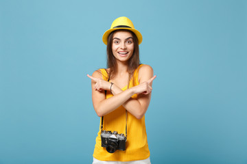 Traveler tourist woman in yellow summer casual clothes, hat with photo camera isolated on blue background. Female passenger traveling abroad to travel on weekends getaway. Air flight journey concept.