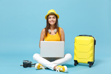 Traveler tourist woman in yellow casual clothes, hat with suitcase laptop pc photo camera isolated...