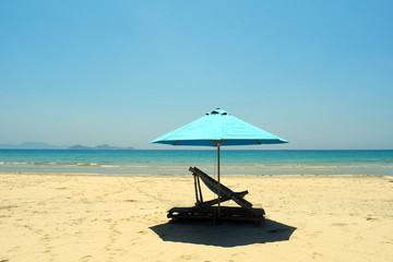 Tourist background. The concept of travel and leisure. Cote d'azur. Pure clear water. White sand. Sun lounger on the beach. Blue beach umbrella.