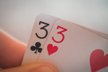 Double three, Playing cards in hand on the table, poker nands
