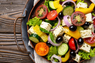 Top view at Mediterranean diet dish greek salad on vintage metal tray