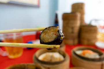 Wooden chopsticks are dim sum on the table.