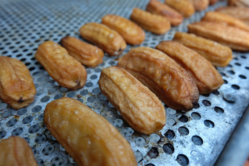Dried bananas are drying on a metal wire rack.