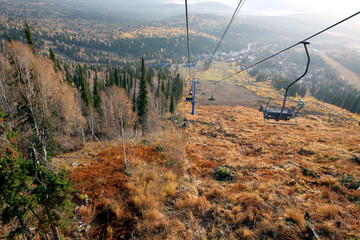 Ski resort in autumn. View from the lift from the top of the mountain. Bright sunny day, yellow...