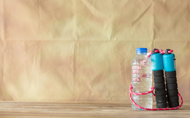 Bottle water and jump rope on wall paper vintage background,