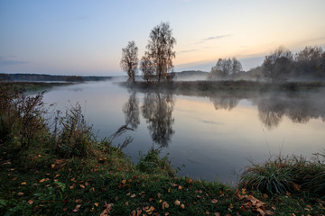 River bank in the morning in the fall with fog.