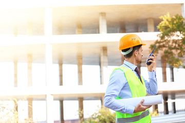 Portrait of male architect with portable radio transmitter in building area