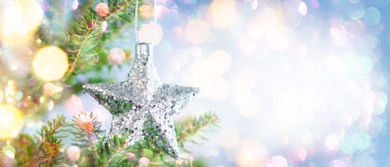 Christmas fir tree branches with silver star decoration  on blurred blue .background. Christmas and...