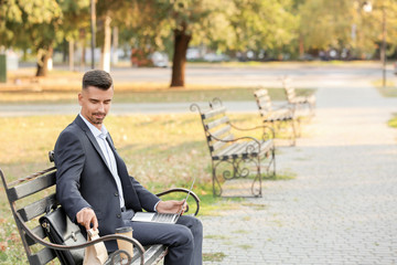Portrait of handsome businessman having lunch in park