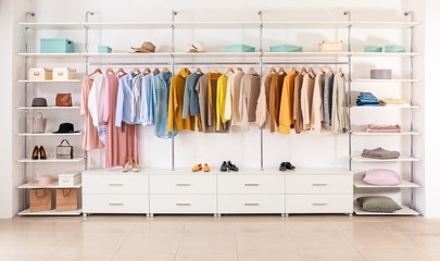 Big wardrobe with clothes in dressing room