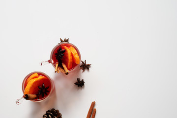 Mulled wine in glass mug with spices. Christmas hot drink on white background. Top view and copy space for text.