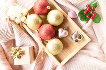 Christmas composition. Christmas balls and gift box decorations on knit background. Christmas, winter, new year concept. Flat lay, top view, copy space.
