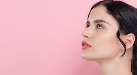 Beautiful young woman with skin care theme on a pink background