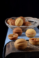 Walnut shaped cookies with condensed milk in a wicker basket on wooden table
