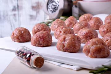 Raw meatballs on the piece of parchment ready to be cooked