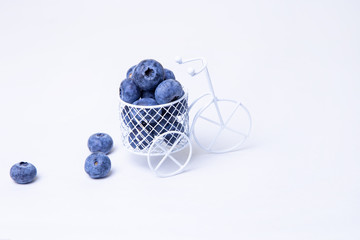 Blueberries in a miniature bike. Close-up, white background.