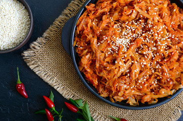 Braised cabbage from tomato sauce in a cast-iron frying pan on a black background. Lenten menu. Diet low-calorie vegetable dish. Close up