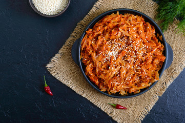 Braised cabbage from tomato sauce in a cast-iron frying pan on a black background. Lenten menu. Diet low-calorie vegetable dish. The top view