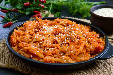 Braised cabbage from tomato sauce in a cast-iron frying pan on a black background. Lenten menu. Diet low-calorie vegetable dish.