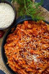 Braised cabbage from tomato sauce in a cast-iron frying pan on a black background. Lenten menu. Diet low-calorie vegetable dish. Close up