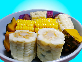 Close-up Steamed Yellow Corns in Bowl Isolated on Blue Background