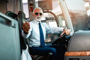 Mature beard bus driver sitting in bus..